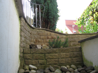 Lichtschachtabmauerung aus handgearbeiteten Bossensteinen - terassenf�rmig angelegt - Abdeckplatten im Halbkreis und handgearbeiteter Bossenkante